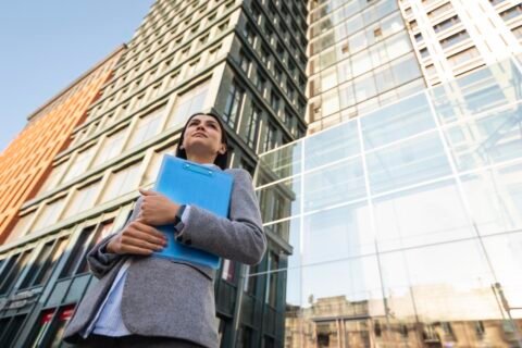 low-angle-businesswoman-holding-clipboard-city
